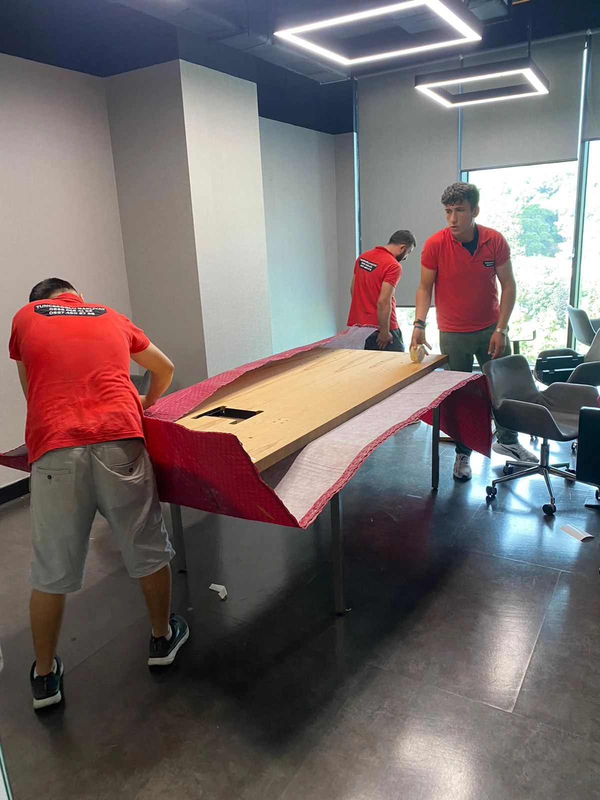 A smiling couple carrying moving boxes into a new house.